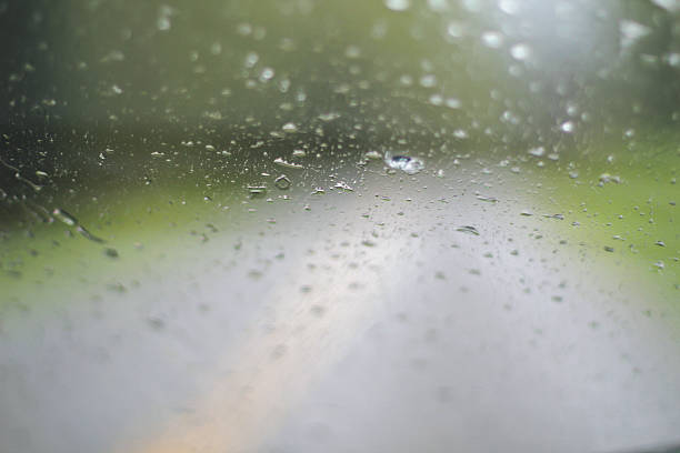 Drops of Rain on a window with vanishing road ahead stock photo