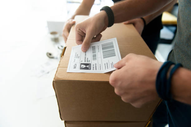 Dropshipping company Worker from startup dropshipping company preparing sticker for the package. labeling stock pictures, royalty-free photos & images