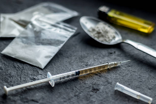 drug syringe and cooked heroin on spoon. drug addict problem and therapy concept drug syringe and cooked heroin on spoon. drug addict problem and therapy concept heroin stock pictures, royalty-free photos & images