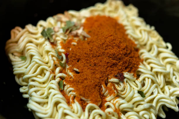 dry instant noodles in a saucepan with spices close-up stock photo