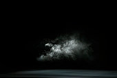 istock Dry white ice smoke clouds fog empty stage textured. Isolated black background. 1305947688