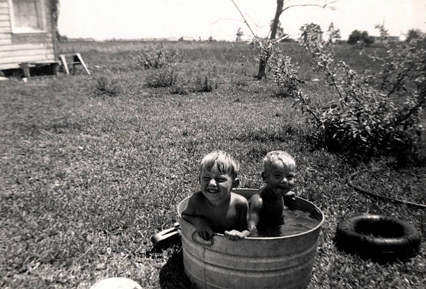 Dub Dub in a Tub "An old family photo of two little guys in their luxurious pool. Original photo is small, there is some noise when blown up." family photos stock pictures, royalty-free photos & images