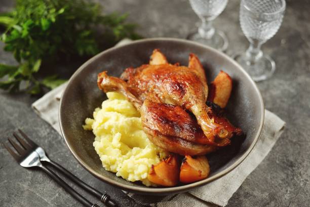 Duck legs in orange juice with quince and mashed potatoes. stock photo