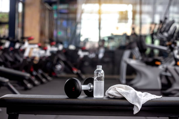 dumbbell, water bottle, towel on the bench in the gym. - elemento ginásio imagens e fotografias de stock