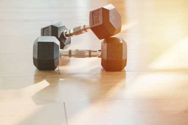 Dumbbells on parquet floor Exercise Room Dumbbells on parquet floor Exercise Room hex dumbbells stock pictures, royalty-free photos & images