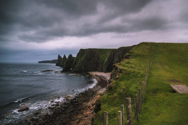 Duncansby Head cliffs and coastline Duncansby Head is the most northeasterly part of the British mainland, including even the famous John o' Groats. cliffs during a stormy, moody, cloudy and rainy day caithness stock pictures, royalty-free photos & images