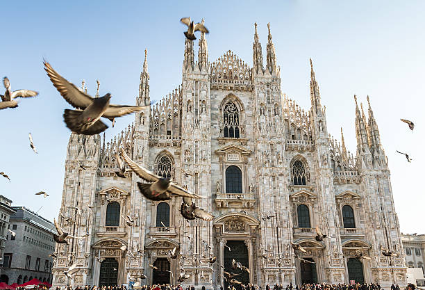 Duomo of Milan and pigeons Duomo of Milan (Italy - Site of Expo 2015) with many pigeons in fly on forward cathedral stock pictures, royalty-free photos & images
