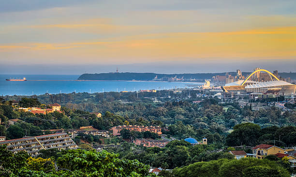 Durban Skyline Durban - South Africa - 20th April 2015. View from North of Durban showing harbour entrance/exit and Moses Mabhida stadium at sunset. durban stock pictures, royalty-free photos & images