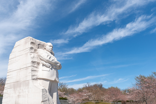 The Martin Luther King Jr memorial sculpture stands tall on a sunny blue sky day. It is located in West Potomac Park in Washington, D.C., southwest of the National Mall, USA.