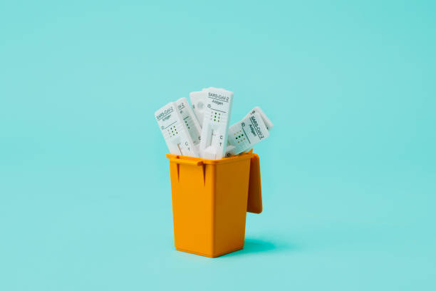 dustbin full of used covid-19 rapid test devices stock photo