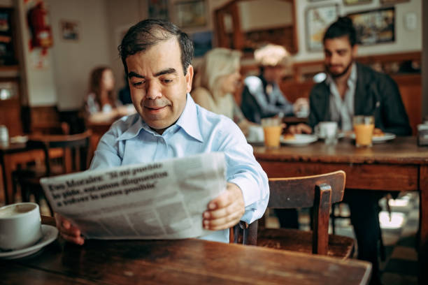 uomo nano legge giornale al bar - nani foto e immagini stock