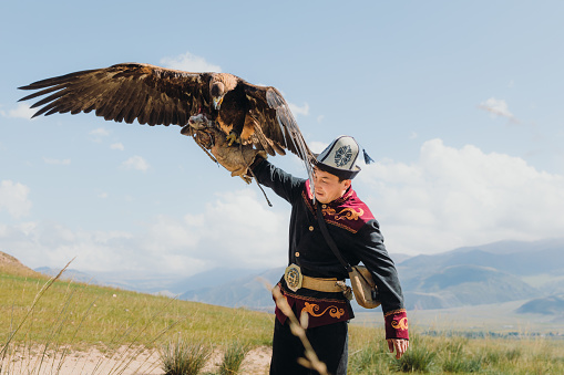Portrait of a man hunter and his Eagle doing an old tradition of eagle hunting in the wilderness area of Tian Shan mountains, Kyrgyzstan