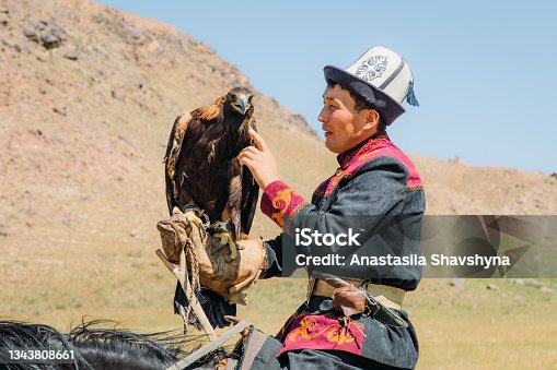 istock Eagle Hunter in traditional costume with Eagle in the mountains of Central Asia 1343808661