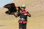 istock Eagle Hunter in traditional costume with Eagle in the mountains of Central Asia 1343808672