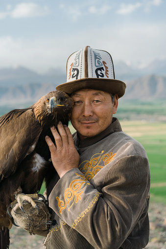 Eagle hunter standing on the background of mountains  in Kyrgyzstan