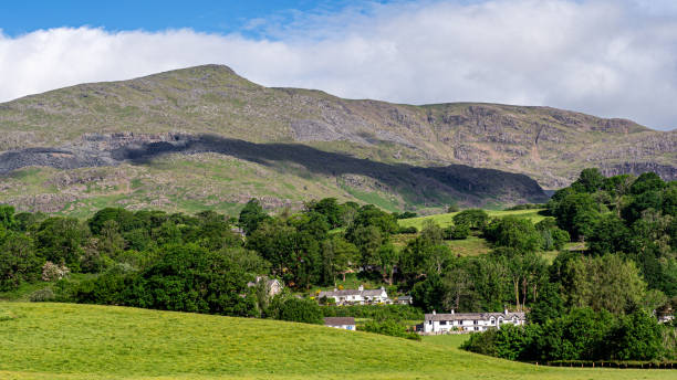 Early morning light on the village of Coniston & the 'Old Man' towering over the village stock photo