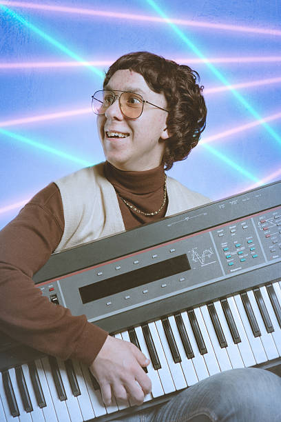 Early Nineties Glamour Shot A late 1980's - early 1990's emulation of a bad school portrait, complete with tacky pink and cyan lasers in the blue background of a young nerd in a turtleneck with a sweater vest and gold chain.  He holds onto a vintage looking keyboard synthesizer.  Low contrast and bad posing; glamour shots at their best/worst! mullet haircut photos stock pictures, royalty-free photos & images