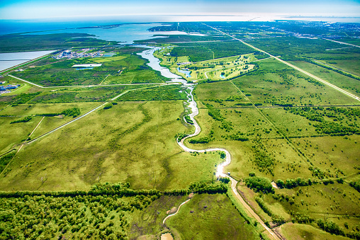 A river known as The Moses Bayou cutting into the rural farmland of East Texas near the Gulf of Mexico coastline near Texas City just north of Galveston.