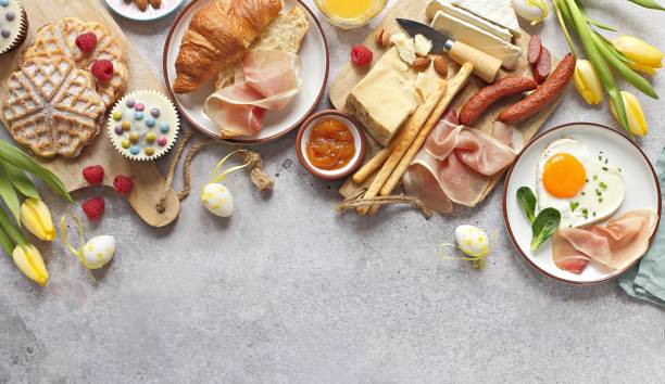 Easter Breakfast food table. Easter Breakfast food table. Festive brunch set, meal variety with fried egg, croissant sandwich, cheese platter and desserts. Overhead view brunch stock pictures, royalty-free photos & images