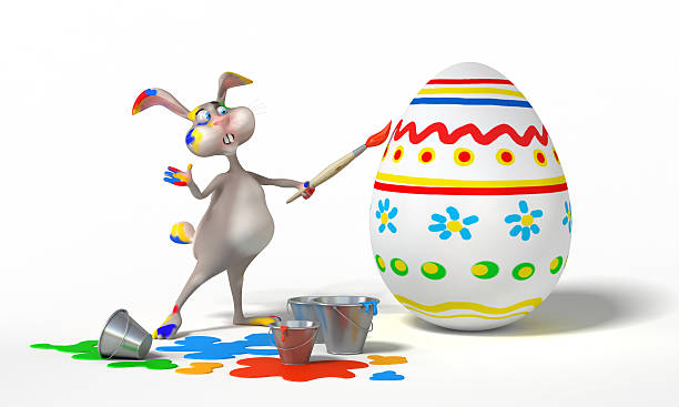 Easter Bunny paints egg stock photo