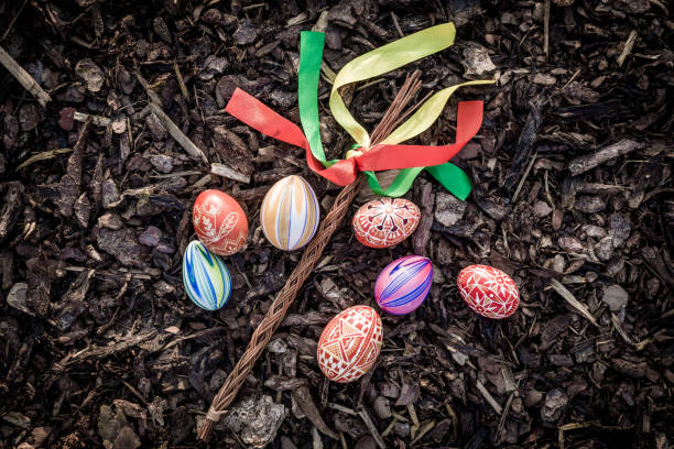 Easter eggplant Easter eggplant made of willow twigs decorated with several colored ribbons. In its vicinity are several typically colorfully decorated Easter eggs. Everything is arranged on a natural bark base. czech culture stock pictures, royalty-free photos & images