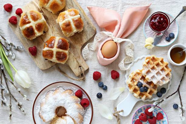 Easter festive dessert table Easter festive dessert table with hot cross buns, cakes, waffles and pancakes. Overhead view brunch stock pictures, royalty-free photos & images
