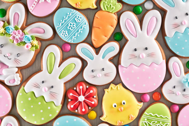 Easter ginger cookies and candies. From above view of colorful ginger glazed cookies and chocolate balls isolated on wooden background. Close up of homemade lovely delicious pastry in shape of easter animals, eggs, flowers and carrots. baked pastry item photos stock pictures, royalty-free photos & images