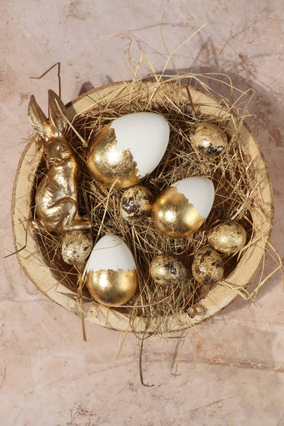 Easter nest basket with golden easter eggs and bunny Easter nest basket with golden easter eggs and bunny easter sunday stock pictures, royalty-free photos & images