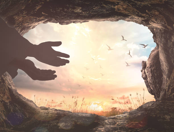 Easter Sunday concept Silhouette Jesus Christ hands with empty tomb stone and birds flying over meadow sunset background tomb stock pictures, royalty-free photos & images