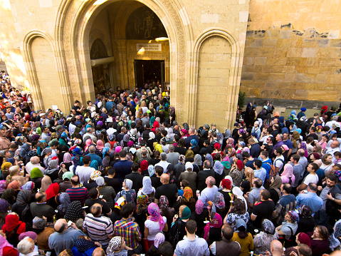 Tbilisi, Georgia - May 1, 2013: A big crowd of people in front of Sioni church in Tbilisi. In background is entrance door to the church and church wall.