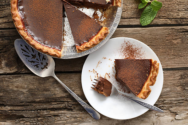 eating a slice of chocolate pie - bolos de chocolate imagens e fotografias de stock