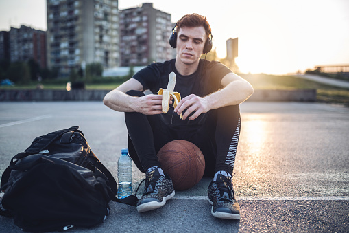 Young and handsome man playing basketball on a basketball court, living the healthy lifestyle.