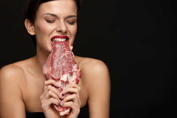 comer carne. mulher bonita, mordendo a carne de bife de carne crua - pessoas comendo carne - fotografias e filmes do acervo