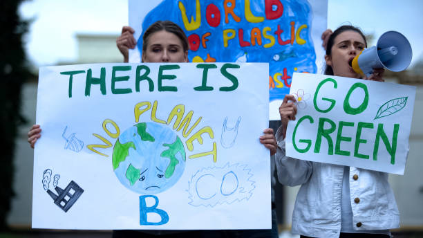 오염, 지구 온난화에 대해 메가폰으로 외치는 현수막을 들고 있는 생태학자들 - 기후 묘사 뉴스 사진 이미지