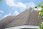 istock edge of Roof shingles on top of the house, dark asphalt tiles on the roof background. 1354850081