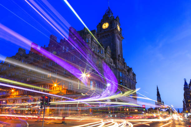Edinburgh at night scene with Speed of Lights Edinburgh at night scene with Lights streak from high-sided vehicles on Princess street and Balmoral hotel on background edinburgh scotland stock pictures, royalty-free photos & images