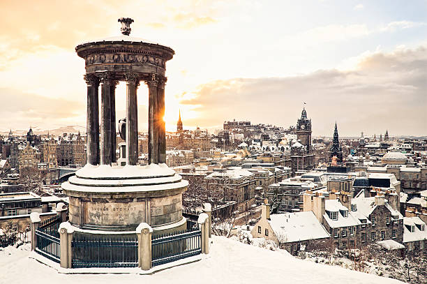 Edinburgh Under Snow The historic city centre of Edinburgh covered in snow, taken at sunset from Calton Hill in December, with the historic Dugald Stewart Monument in the foreground. edinburgh scotland stock pictures, royalty-free photos & images