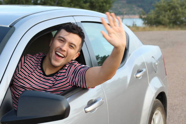 Educated driver saluting a friend Educated driver saluting a friend. wave goodbye asian stock pictures, royalty-free photos & images