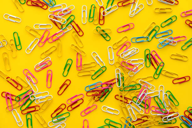 Education and back to school concept. Colourful paper clips on bright yellow background stock photo