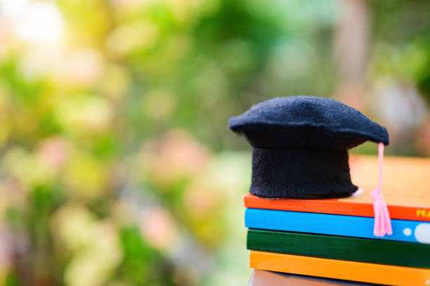 Education concept : Graduation hat or Mortarboard put on many book with background natural background.  mba stock pictures, royalty-free photos & images