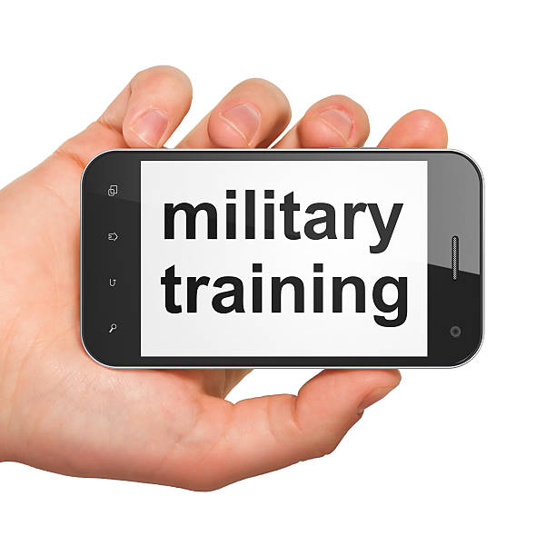 Education concept: Military Training on smartphone Education concept: hand holding smartphone with word Military Training on display. Generic mobile smart phone in hand on White background. military schools stock pictures, royalty-free photos & images