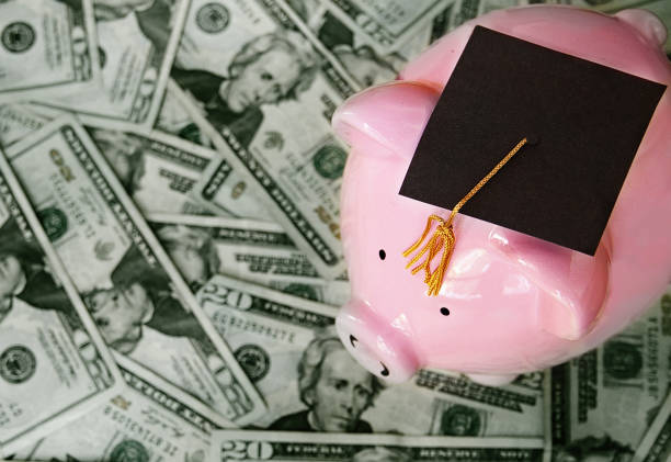 education cost concept piggy bank with graduation cap on cash student loan stock pictures, royalty-free photos & images
