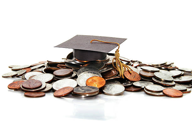 Education costs graduation cap  on a pile of money ( student debt ) student debt stock pictures, royalty-free photos & images