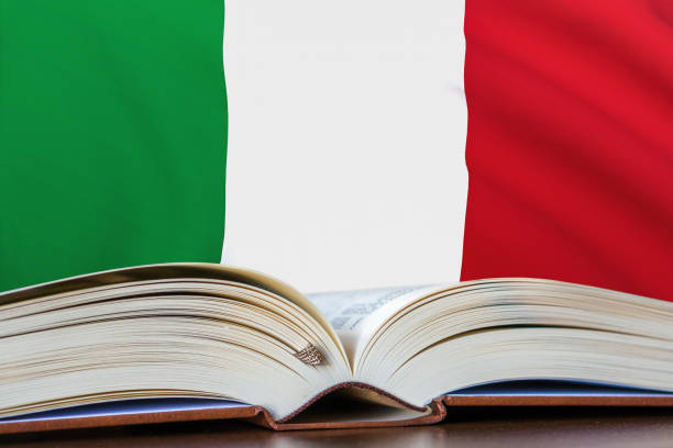 Education in Italy. Opened book and national flag on background. stock photo