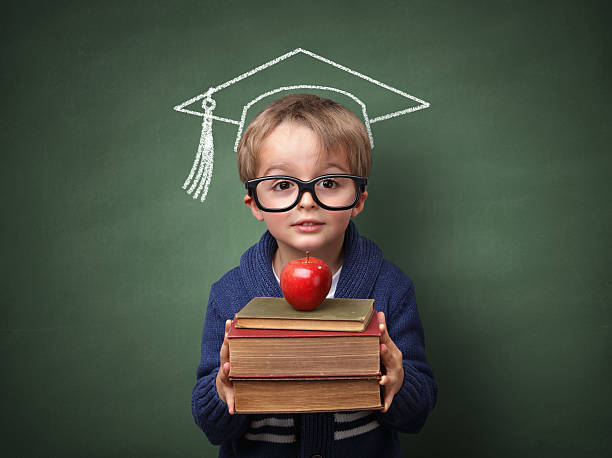 Education Child holding stack of books with mortar board chalk drawing on blackboard concept for university education and future aspirations chalk drawing photos stock pictures, royalty-free photos & images