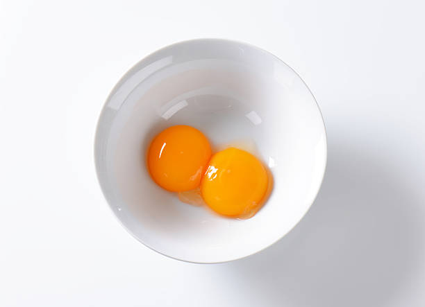 egg yolks two raw egg yolks in white bowl on white background egg yolk stock pictures, royalty-free photos & images