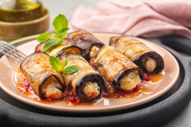 Eggplant roll ups with ricotta, parmesan cheese and tomato sauce. stock photo