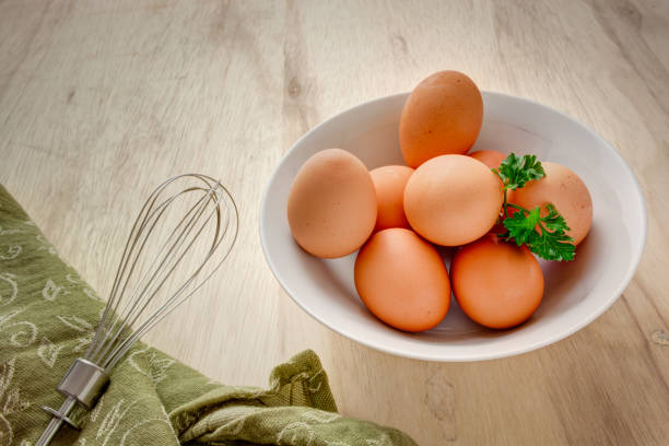 eggs in a bowl with whisk stock photo