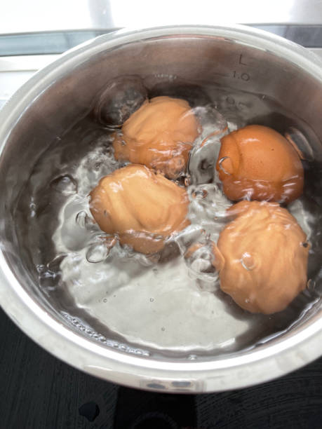 eggs in water boiling stock photo
