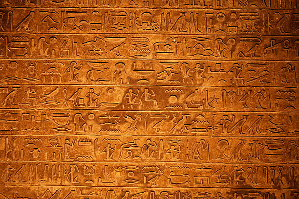 Egyptian Hieroglyphics on a beige stone stock photo